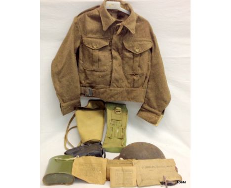 A 1940 pattern Battledress with a 1940 dated British Army helmet and other WW2 pouches First Aid dressings etc