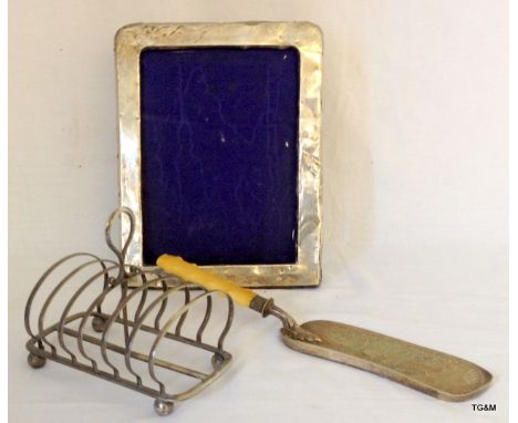A silver picture frame, Victorian silver plated toast rack and a crumb tray with bone handle