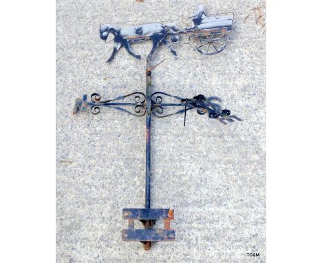 A cast iron weather vane depicting a horse and carriage