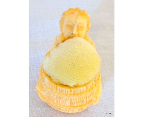 A well carved bone mermaid in the form of a pin cushion