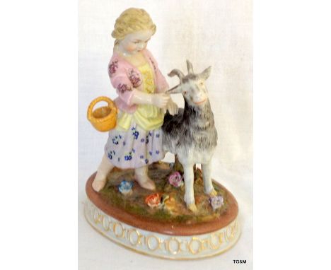 A ceramic figure of a child and her goat
