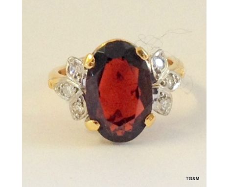 A 9ct gold ring set with a 4ct garnet and a 1ct diamond, size K