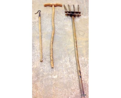 A vintage wooden pitch fork, wooden sheep dipper and shepherds crook