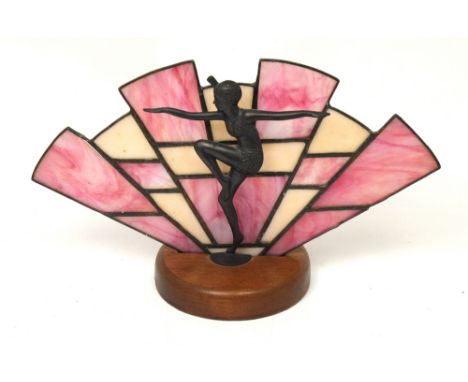 An Art Deco table lamp, stepped fan-shape pink and cream opaque glass panels behind an exotic young lady dancer, on a circula