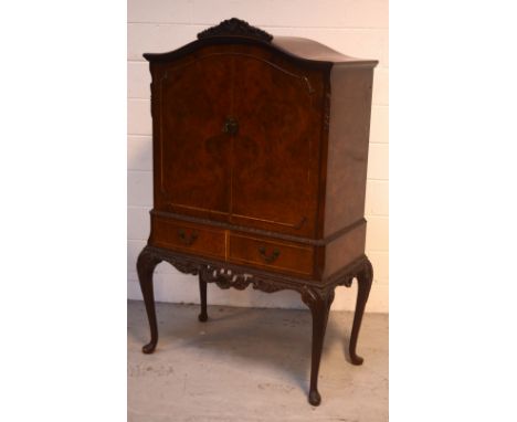 A mid-20th century burr walnut Epstein-style cocktail cabinet with fitted interior, mirrored back and glass shelf, above two 