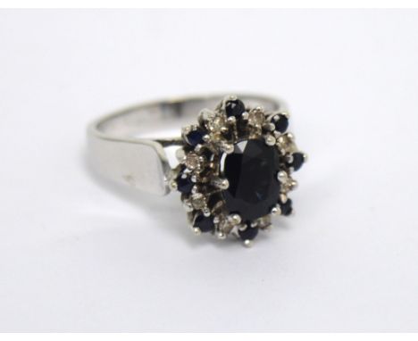 A 9ct white gold dress ring, floral-set with central topaz with diamond chip and topaz surround, size M, approx 4.3g.