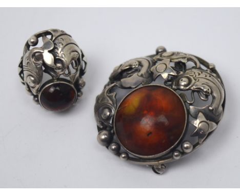 Niels Erik From, Denmark; a 925 silver circular brooch mounted with an amber cabochon surrounded by stylised fish, with a mat