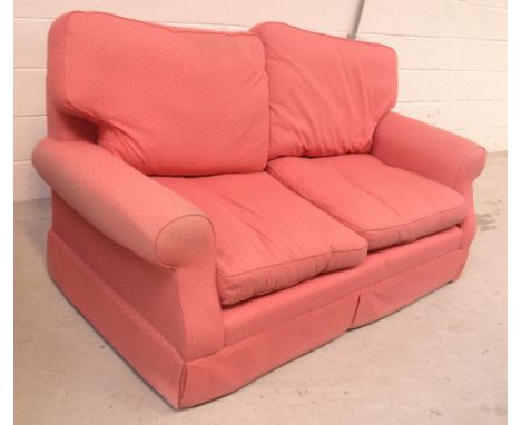 A contemporary two-seater upholstered sofa by Laura Ashley, upholstered in raspberry coloured fabric, length 175cm.