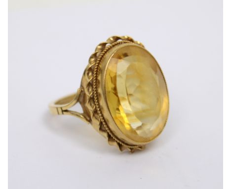 A 9ct gold dress ring set with a large oval pale yellow stone, size N, approx 6.4g.