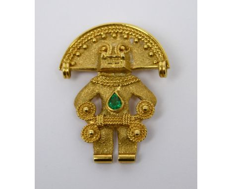 A yellow metal pendant/brooch in the form of an Inca god, set with central pear-cut green stone, stamped to reverse 18k, appr