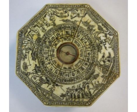 A 20thC Japanese octagonal bone clad table compass engraved and inked around the dial with figures, small boats, domestic art