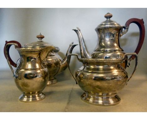 A four piece silver tea set of squat, bulbous form with decoratively cast border ornament  comprising a teapot, having an ins