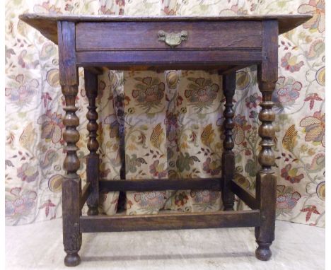 A George III oak side table, having a planked top, over a long drawer, raised on bobbin and disk turned, block legs, united b