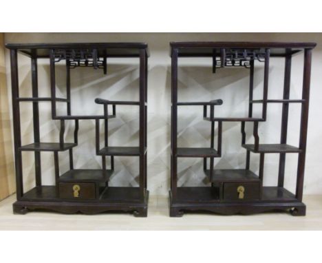 A pair of 20thC Chinese hardwood display table stands, each having a panelled top, over an arrangement of offset shelves and 