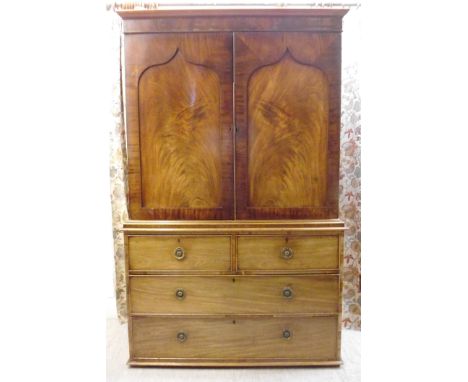 An early Victorian mahogany linen press, having a straight cornice, over a pair of painted, arched, flame veneered, panelled 