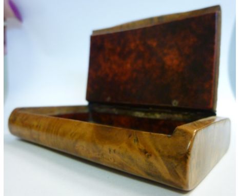 An early 19thC cushion shaped, figured walnut snuff box, the hinged lid with basketweave decoration, enclosing a red tortoise