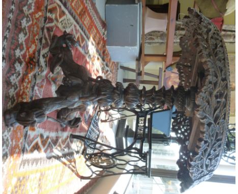 A late 19thC Anglo-Indian profusely carved hardwood table, the top with an angled apron, ornamented with flora and foliage, o