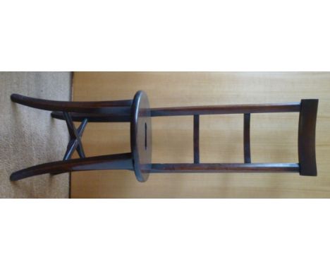 A 19thC mahogany framed correction chair/stool, having a straight, high ladder back, the solid oval seat incorporating a cut-
