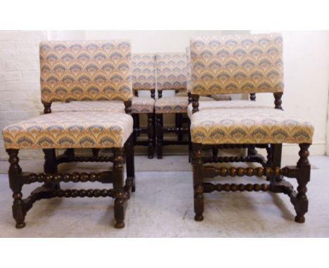 A set of eight 20thC reproductions of Charles II oak framed dining chairs, each having a rectangular tapestry back and seat, 