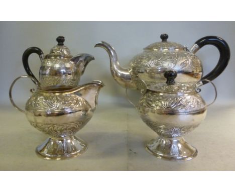 A four piece Middle Eastern silver coloured metal (.9584) tea set  comprising a teapot of squat, bulbous form, having an ebon