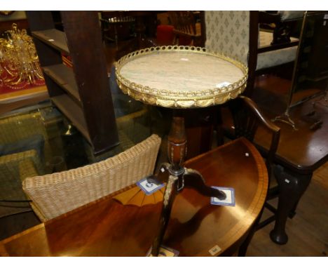 A small circular marble top wine table raised on a turned column and tripod base with applied metal mount 