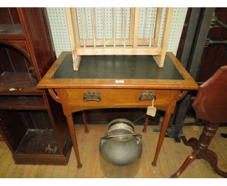 An Arts & Crafts oak card tableOf rectangular form, having green leather inset top rotating and opening to reveal card table,