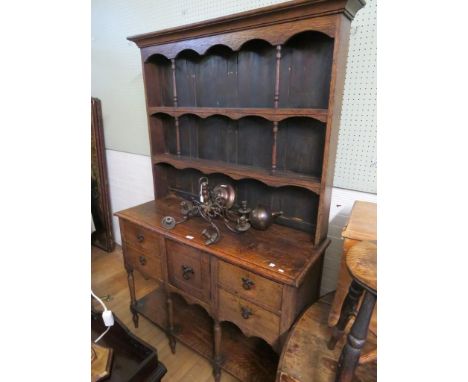 An early 20th Century oak dresser cabinet with two shelf back over a base with four drawers, single door and pot board shelf 