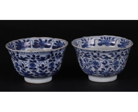 Two porcelain cups with tulip-shaped outer beds&nbsp;and floral decoration, in the center a blossom branch on a rock decorati
