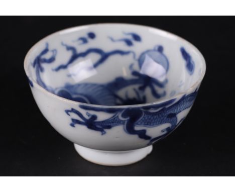 A porcelain wine cup with a clawing dragon chasing&nbsp;a flaming pearl, marked with a seal mark. China Kanxi.Diam.: 7.5 cm.H