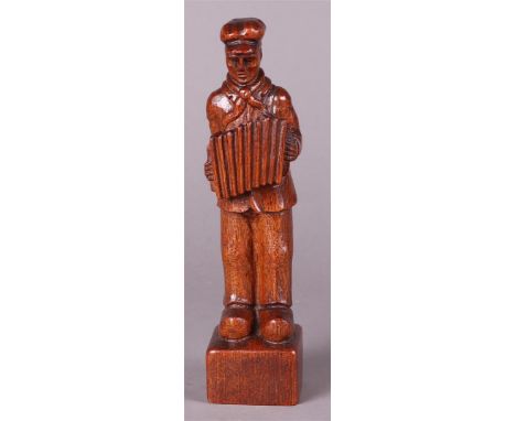 An oak sculpture of a farmer with an accordion, unclearly monogrammed in the foot.H.: 27 cm. 
