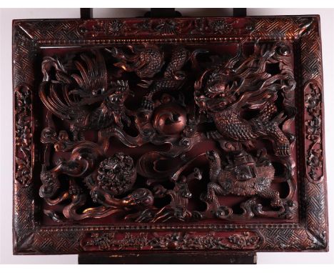 A large wooden panel depicting figures such as dragons, Foo-dogs and phoenixes. China, 20th century.Afm. 62 x 84 cm.
