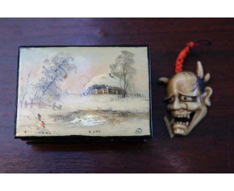 Russian Lacquered box depicting a Winter scene signed to bottom left and a a Bone Carved Netsuke of a Demon Face 