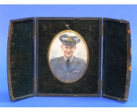 A portrait miniature of a young R.A.F. officer, possibly W.W.2 period, oval photographic portrait over-painted in colours, wi