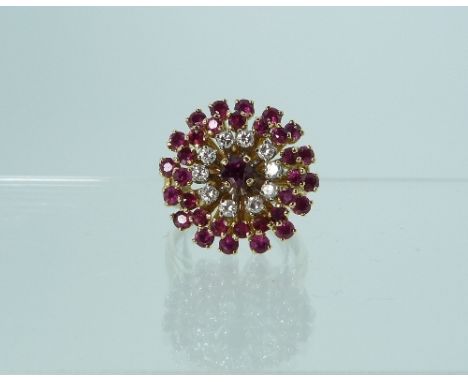 A Dress Ring, of large circular form, comprising concentric circles of rubies and diamonds, with a larger ruby centre, mounte