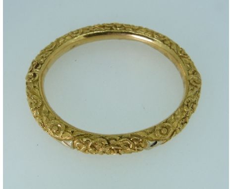 An 18ct yellow gold hollow Hinged Bangle, the front and reverse foliate engrave, marked on the tongue 750, approx weight 16.2
