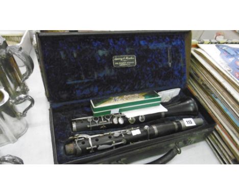 A CASED CLARINET AND HARMONICA