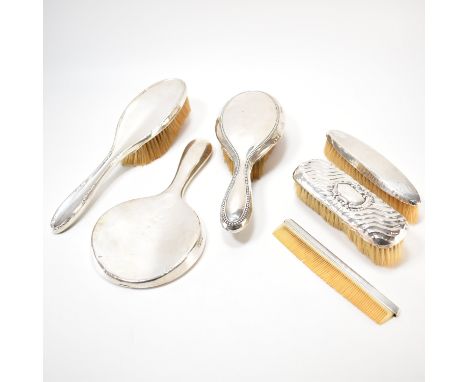 A group of antique silver backed dressing table items. The lot to include two hair brushes, two clothes brushes, a comb and a