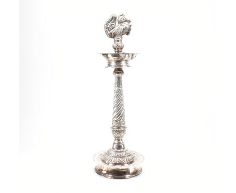 A 20th Century Indian silver Samai oil lamp. The lamp featuring a bird finial to the top with a twisted reeded column on a ro