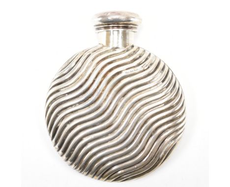 A silver hallmarked whisky flask. The flask having a round body with repousse wave detailing with a screw cap to the top. Hal