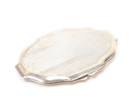 A vintage mid 20th Century silver compact. The compact having engine turned decoration to the exterior and opening to reveal 