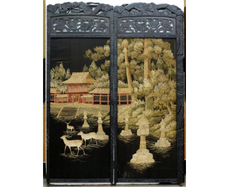 A South East Asian ebonised two leaf screen, with needlework landscape panel, the frame carved with dragons and finches, 157c