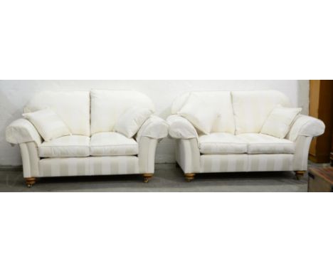 A pair of modern chesterfield sofas, in white stripe upholstery, on light wood bun feet with brass castors, 167cm l, matching
