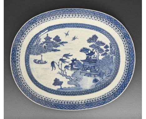 A Chinese export blue and white dish, late 18th c, painted with a river scene in spearhead and cell diaper borders, 33cm l  N