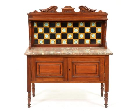 A Victorian carved mahogany marble topped wash stand, with tiled splash back, the lower part enclosed by panelled doors on tu