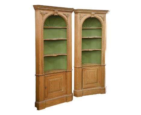 A pair of pine standing corner cabinets, 20th c, with dentil cornice and carved acanthus keystone to the egg-and-dart arch fr