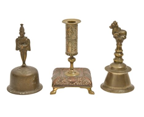 Two English brass hand bells, late 19th c, 18 and 19cm h and a copper and brass candlestick (3)  Flange of one bell chipped