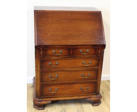 Reproduction mahogany  bureau, the fall front enclosing fitted interior over two short and three long drawers on carved brack