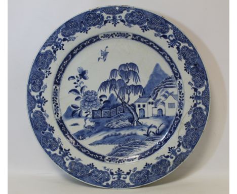 Large 18th century Chinese blue and white circular charger, the central landscape panel depicting a house and garden surround