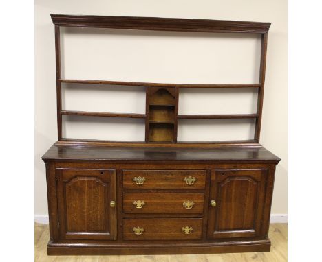 Antique oak dresser, the open plate rack with three central shelves, the base with half pilasters fitted with three graduated