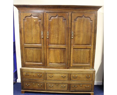 Antique oak press cupboard enclosed by three panel doors over three dummy drawers with drawers below, on bracket feet. 159cm 